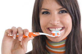 A woman holding a toothbrush ready to brush her teeth